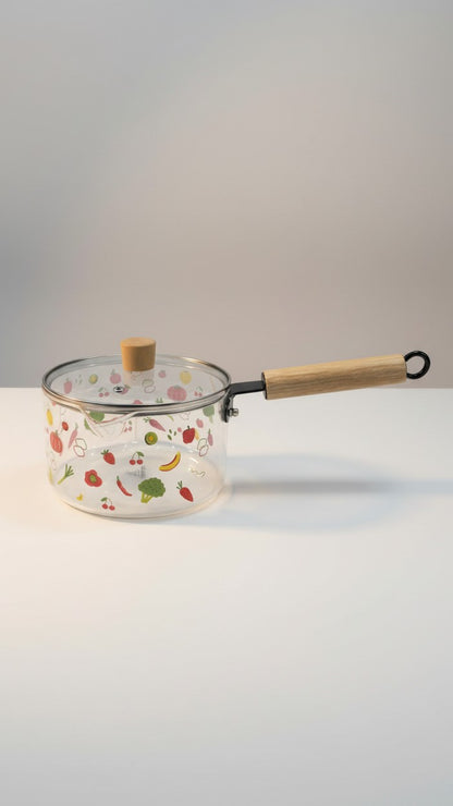 Asoula clear glass saucepan with lid, featuring a fun fruit and vegetable print. Oven-safe for versatile cooking.