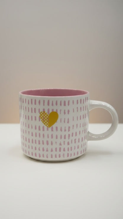 Asoula white ceramic mug with pink dash pattern and a yellow heart detail. Pink interior.