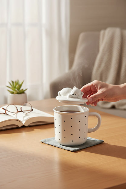 Asoula white porcelain mug with black polka dots and a lid featuring a sleeping bear.