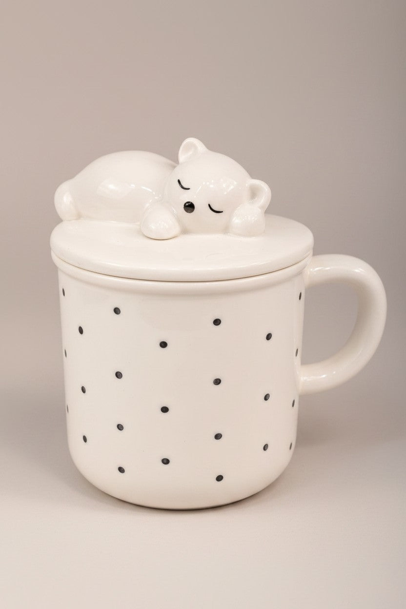 Asoula white porcelain mug with black polka dots and a lid featuring a sleeping bear.